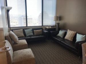 Glendale office room 1704, two brown sofas with pillows, two light tan chairs