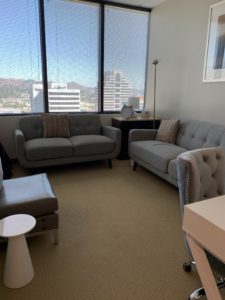 Glendale office room 1702, two tan sofas, large windows