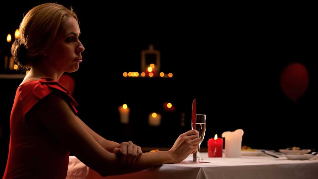 A woman looking distressed and overwhelmed while a man stands nearby, illustrating dating anxiety and the feeling of a nervous system trigger.