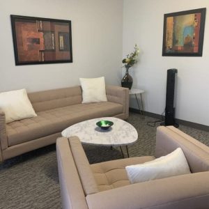 sherman oaks suite 1208, room 4, two tan sofas, paintings on walls